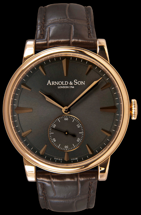 This watch features a beautiful, elegant case crafted from 18kt rose gold. It has a sapphire crystal over the anthracite colored dial. The dial functions include hours, minutes, and small seconds at the 6 o’clock position. The gold hour indexes and hands are polished and faceted. Powering this watch is the hand- wound A&S 1001 calibre movement. This is an in-house calibre movement featuring two barrels for a power reserve of 90 hours.