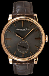 This watch features a beautiful, elegant case crafted from 18kt rose gold. It has a sapphire crystal over the  anthracite colored dial.  The dial functions include hours, minutes, and small seconds at the 6 o’clock position. The gold hour indexes and hands are polished and faceted.  Powering this watch is the hand- wound A&S 1001 calibre movement. This is an in-house calibre movement featuring two barrels for a power reserve of 90  hours.