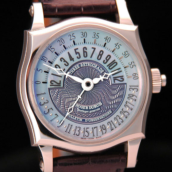 8kt white gold case with a manual winding movement. The blue Mother of Pearl and Guilloche dial has Arabic numerals, and the first triple retrograde function to work from a central pivot. The movement can be viewed through the sapphire crystal display back. Watch comes on a black crocodile strap with an 18kt white gold tang buckle. This watch is number 8 out of 28 for the world.